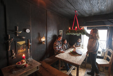 Eltern mit zwei Kindern in einem Bauernhauszimmer im Advent - HHF005409