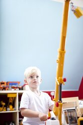 Kleiner Junge spielt mit Spielzeugkran im Kinderzimmer - MFRF000408