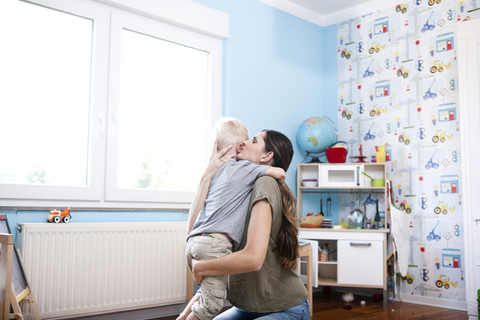 Mutter und kleiner Sohn zusammen im Kinderzimmer, lizenzfreies Stockfoto