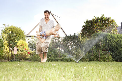 Vater und sein kleiner Sohn haben Spaß im Garten - MFRF000451