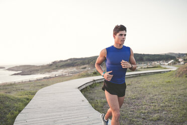 Spain, Ferrol, jogger running on a boardwalk - RAEF000479