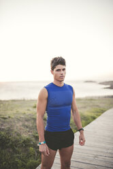 Spain, Ferrol, portrait of a jogger standing on boardwalk - RAEF000478