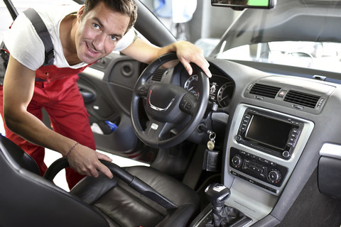 Autoreinigung, Mann beim Staubsaugen im Auto, lizenzfreies Stockfoto