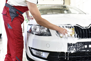 Autoreinigung, Mann reinigt Auto mit Schwamm - LYF000478