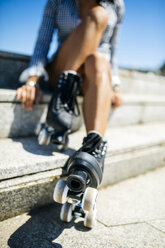 Spanien, Gijon, junges Mädchen mit Rollschuhen auf einer Treppe sitzend - MGOF001000