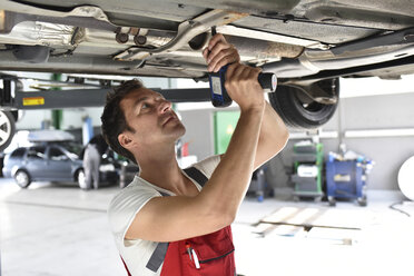 Automechaniker bei der Arbeit in einer Reparaturwerkstatt, Reparatur des Unterbodens - LYF000527