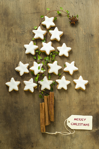 Weihnachtsbaumform aus Zimtsternen und Stäbchen auf Holz, lizenzfreies Stockfoto