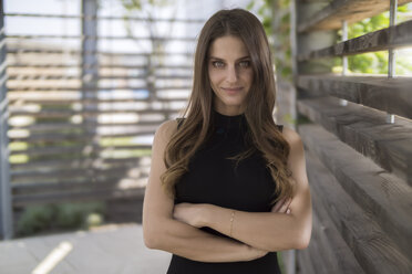 Portrait of confident young woman in pergola - RIBF000320