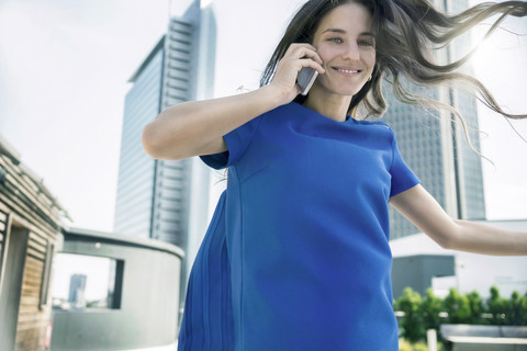 Lächelnde junge Frau am Handy im Freien, lizenzfreies Stockfoto