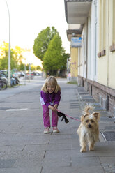 Kleines Mädchen auf dem Bürgersteig mit ihrem Hund - JFEF000694