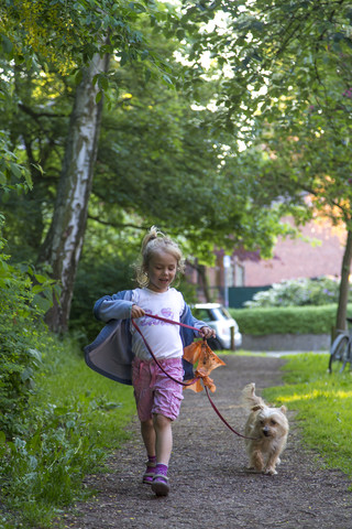 Kleines Mädchen geht mit ihrem Hund spazieren, lizenzfreies Stockfoto