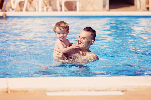 Tattooed man with his little son in the swimming pool - XCF000004