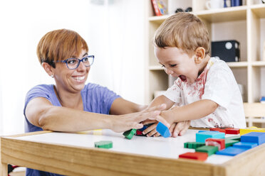 Portrait of little boy and his mother playing together with building bricks - JRFF000057