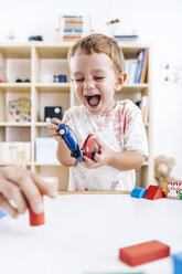 Porträt eines lachenden kleinen Jungen, der mit Spielzeugautos spielt - JRFF000063