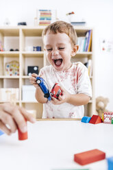Portrait of laughing little boy playing with toy cars - JRFF000063