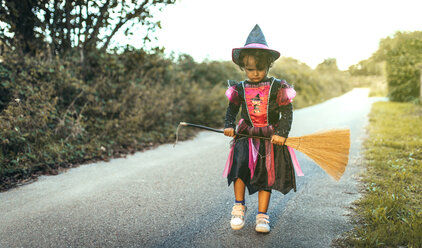 Porträt eines unglücklichen kleinen Mädchens, das sich als Hexe verkleidet - MGOF000677