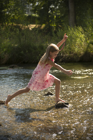 Girl walking through a brook stock photo