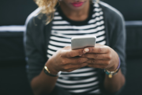 Frau hält Smartphone in den Händen, lizenzfreies Stockfoto