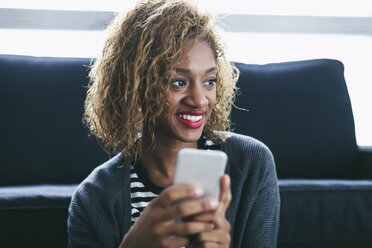 Portrait of smiling young woman with her smartphone - EBSF000892