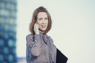 Portrait of redheaded businesswoman telephoning with smartphone - TAMF000303