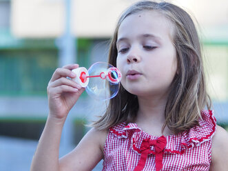 Portrait of little girl making soap bubble - XCF000010