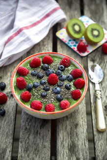 Grüner Kiwi-Smoothie mit Blaubeeren und Himbeeren und Chiasamen in Schale - SARF002086