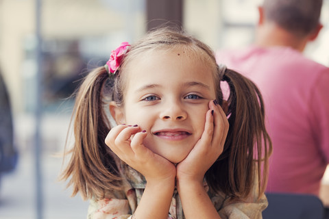 Portrait of little girl with head in her hands stock photo