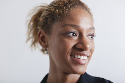 Porträt einer lächelnden Frau vor einem weißen Hintergrund, lizenzfreies Stockfoto