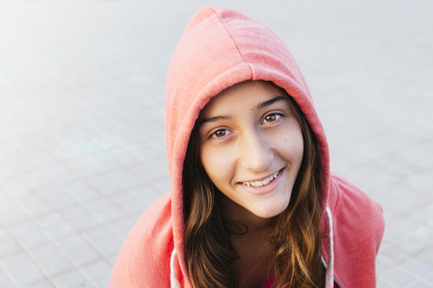 Portrait of smiling girl wearing red hooded jacket stock photo