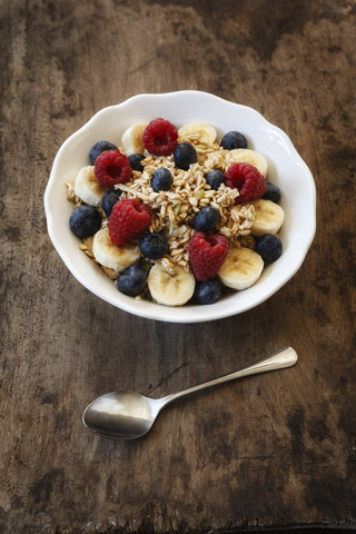 Bowl of muesli with banana slices, raspberries and blueberries stock photo