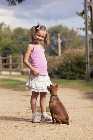 Porträt eines lächelnden kleinen Mädchens mit ihrem Hund, lizenzfreies Stockfoto