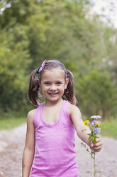 Portrait of smiling little girl showing flowers - XCF000019
