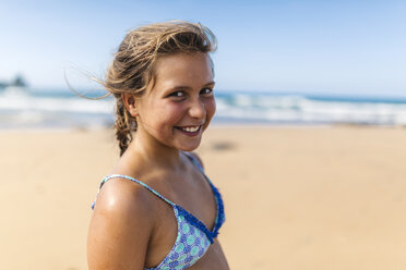 Porträt eines lächelnden Mädchens mit Bikinioberteil am Strand - MGOF000710