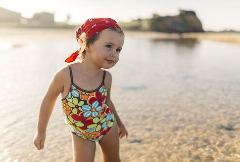 Porträt eines lächelnden kleinen Mädchens im Badeanzug mit floralem Muster - MGOF000724