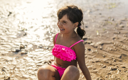 Porträt eines lächelnden kleinen Mädchens im rosa Bikini am Strand - MGOF000727
