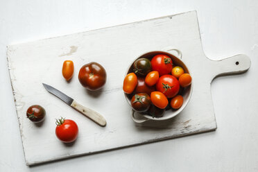 Verschiedene Tomaten, Zebrino, Ebeno, Devotion und gelbe Kirschtomaten auf Schneidebrett, Küchenmesser, Schüssel - EVGF002279