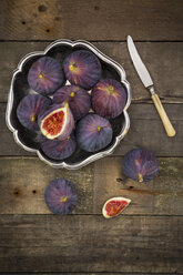 Bowl of figs and a knife on dark wood - LVF003831