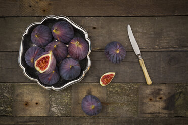 Bowl of figs and a knife on dark wood - LVF003832