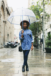 Spain, Barcelona, portrait of young woman with umbrella wearing hat and denim shirt - EBSF000925