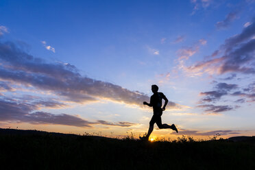 Mann joggt bei Sonnenuntergang - STSF000910