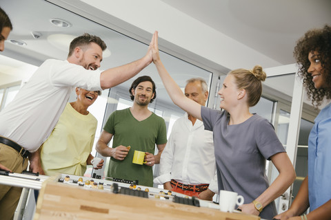 Bürokollegen spielen in der Pause Tischfußball, lizenzfreies Stockfoto