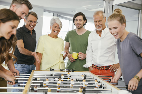 Bürokollegen spielen in der Pause Tischfußball, lizenzfreies Stockfoto