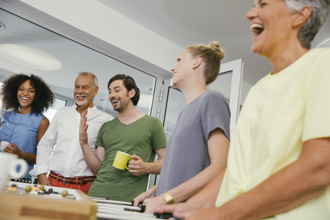 Bürokollegen spielen in der Pause Tischfußball, lizenzfreies Stockfoto