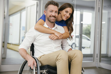 Man in wheelchair with his girlfriend, embracing happily - MFF002227