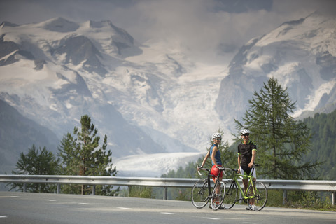 Schweiz, Engadin, zwei Radfahrer auf der Berninapassstrasse vor dem Morteratschgletscher, lizenzfreies Stockfoto