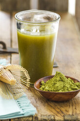 Glass of matcha tea, bowl with matcha powder and a tea whisk - ODF001327