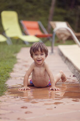 Porträt eines lächelnden kleinen Jungen neben einem Schwimmbad - XCF000022