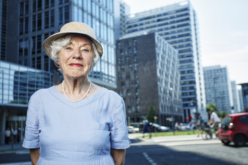 Deutschland, Berlin, Porträt einer lächelnden älteren Frau mit Hut und Sommerkleid - TAMF000341
