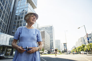 Deutschland, Berlin, Porträt einer lächelnden älteren Frau, die etwas beobachtet - TAMF000343