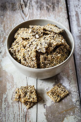 Seed crackers with hemp seeds in bowl, on wood - EVGF002291